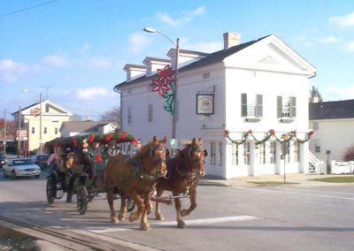 horse drawn wagon going past historic Rochester Inn in Sheboygan Falls